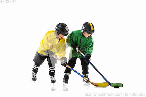 Image of Little hockey players with the sticks on ice court and white studio background