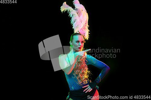 Image of Beautiful young woman in carnival and masquerade costume in colorful neon lights on black background