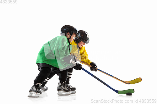 Image of Little hockey players with the sticks on ice court and white studio background