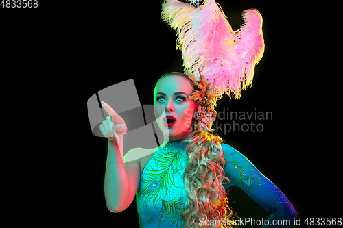 Image of Beautiful young woman in carnival and masquerade costume in colorful neon lights on black background