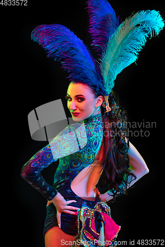 Image of Beautiful young woman in carnival and masquerade costume in colorful neon lights on black background