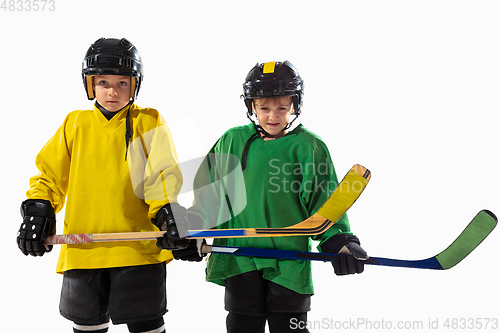 Image of Little hockey players with the sticks on ice court and white studio background