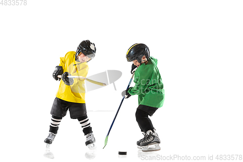 Image of Little hockey players with the sticks on ice court and white studio background