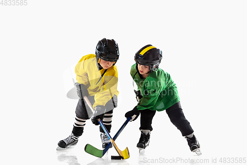 Image of Little hockey players with the sticks on ice court and white studio background