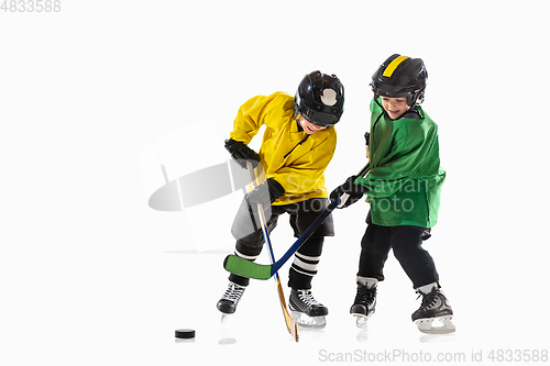 Image of Little hockey players with the sticks on ice court and white studio background