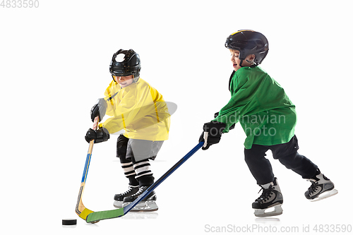 Image of Little hockey players with the sticks on ice court and white studio background