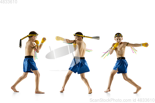 Image of Little boy exercising thai boxing on white background. Fighter practicing, training in martial arts in action, motion. Evolution of movement, catching moment.