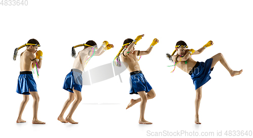 Image of Little boy exercising thai boxing on white background. Fighter practicing, training in martial arts in action, motion. Evolution of movement, catching moment.