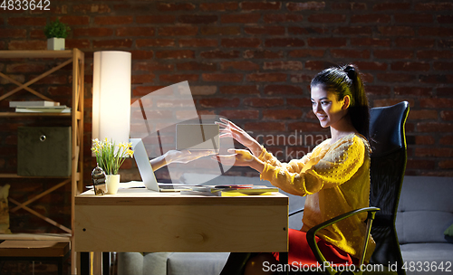 Image of Young Caucasian woman talking with friend online through laptop.