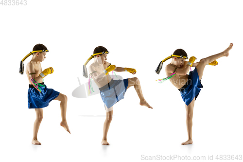 Image of Little boy exercising thai boxing on white background. Fighter practicing, training in martial arts in action, motion. Evolution of movement, catching moment.