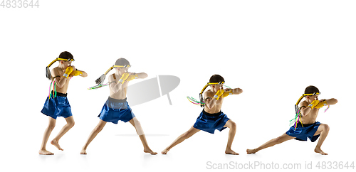 Image of Little boy exercising thai boxing on white background. Fighter practicing, training in martial arts in action, motion. Evolution of movement, catching moment.