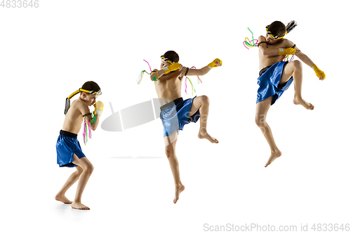 Image of Little boy exercising thai boxing on white background. Fighter practicing, training in martial arts in action, motion. Evolution of movement, catching moment.