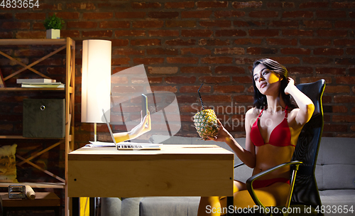 Image of Young Caucasian woman talking with friend online through laptop.