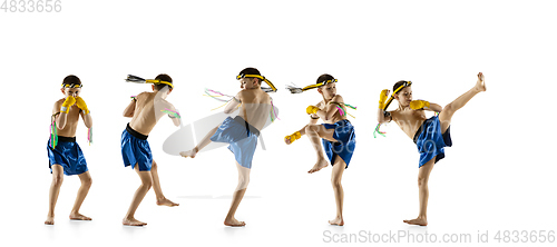 Image of Little boy exercising thai boxing on white background. Fighter practicing, training in martial arts in action, motion. Evolution of movement, catching moment.