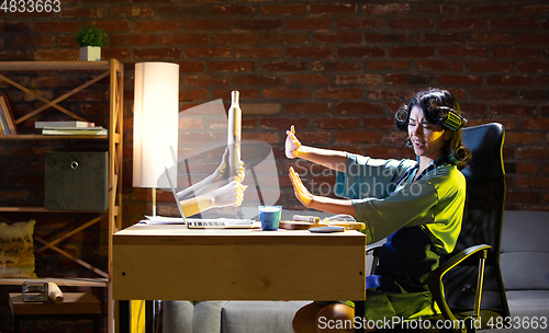 Image of Young Caucasian woman during online cooking lesson through laptop.