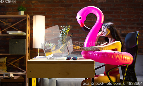 Image of Young Caucasian woman talking with friend online through laptop.