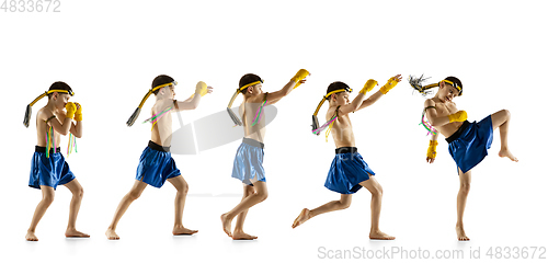 Image of Little boy exercising thai boxing on white background. Fighter practicing, training in martial arts in action, motion. Evolution of movement, catching moment.