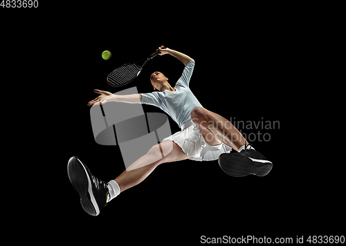 Image of Female professional tennis player in action, motion isolated on black background, look from the bottom. Concept of sport, movement, energy and dynamic.