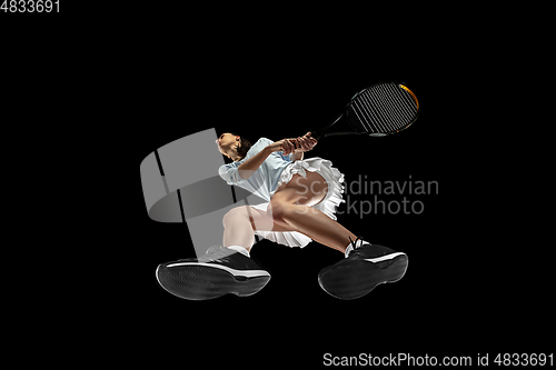 Image of Female professional tennis player in action, motion isolated on black background, look from the bottom. Concept of sport, movement, energy and dynamic.