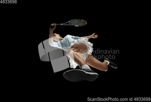 Image of Female professional tennis player in action, motion isolated on black background, look from the bottom. Concept of sport, movement, energy and dynamic.