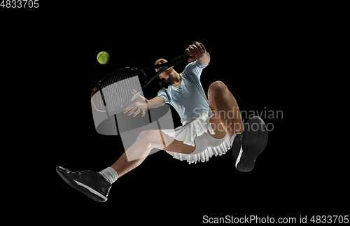 Image of Female professional tennis player in action, motion isolated on black background, look from the bottom. Concept of sport, movement, energy and dynamic.