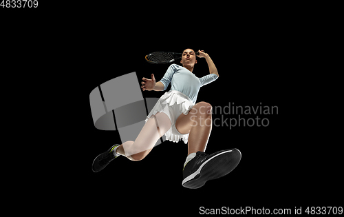 Image of Female professional tennis player in action, motion isolated on black background, look from the bottom. Concept of sport, movement, energy and dynamic.