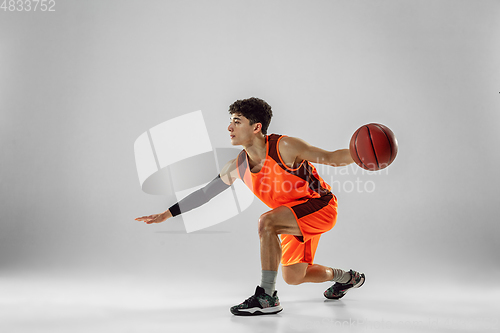 Image of Young basketball player training isolated on white studio background