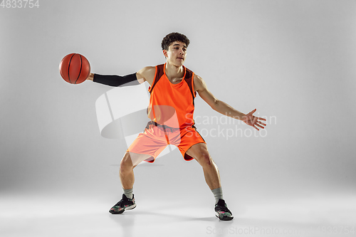 Image of Young basketball player training isolated on white studio background