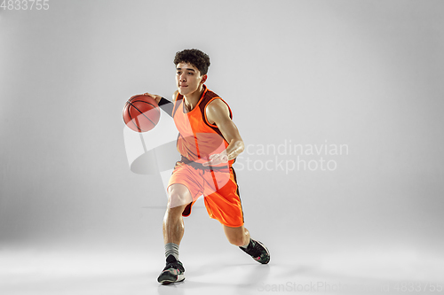 Image of Young basketball player training isolated on white studio background