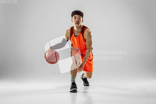 Image of Young basketball player training isolated on white studio background