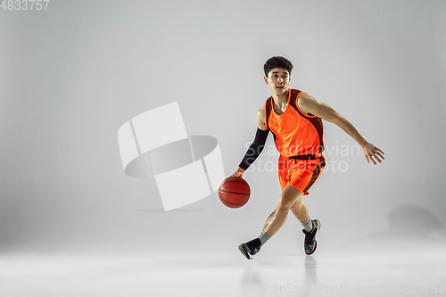 Image of Young basketball player training isolated on white studio background