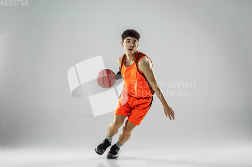 Image of Young basketball player training isolated on white studio background