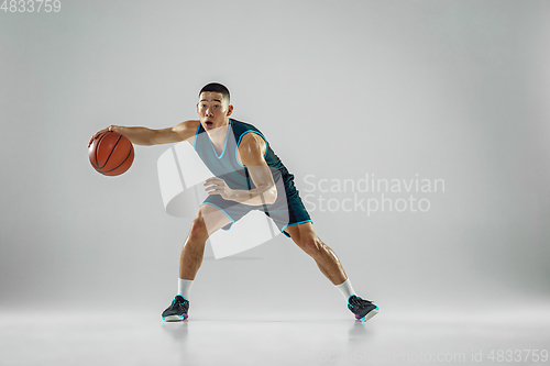 Image of Young basketball player training isolated on white studio background