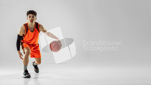 Image of Young basketball player training isolated on white studio background