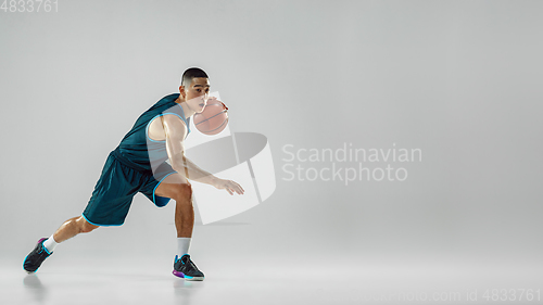 Image of Young basketball player training isolated on white studio background