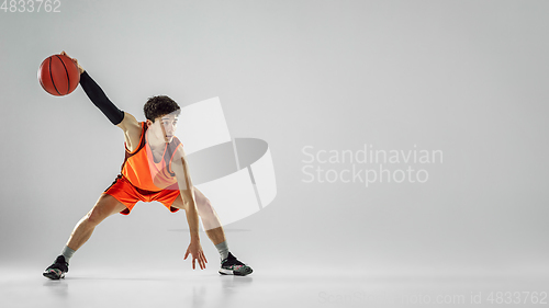 Image of Young basketball player training isolated on white studio background