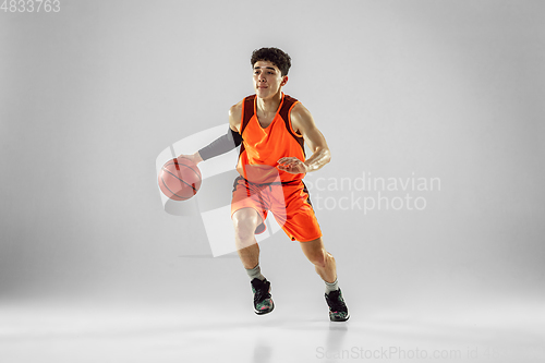 Image of Young basketball player training isolated on white studio background