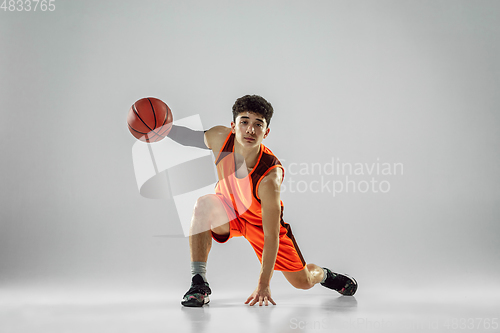 Image of Young basketball player training isolated on white studio background