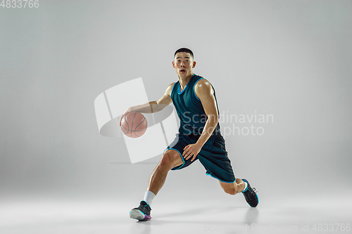 Image of Young basketball player training isolated on white studio background