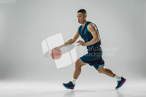 Image of Young basketball player training isolated on white studio background