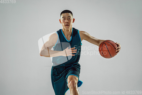 Image of Young basketball player training isolated on white studio background