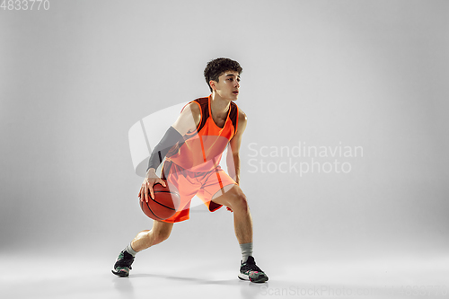 Image of Young basketball player training isolated on white studio background