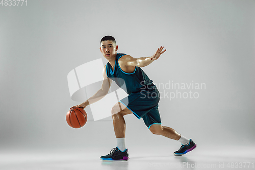 Image of Young basketball player training isolated on white studio background