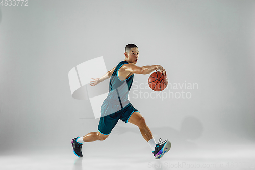 Image of Young basketball player training isolated on white studio background