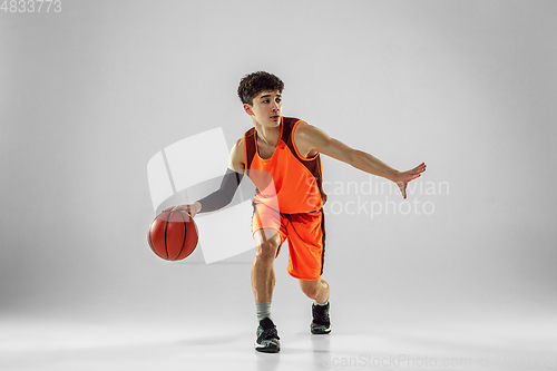 Image of Young basketball player training isolated on white studio background