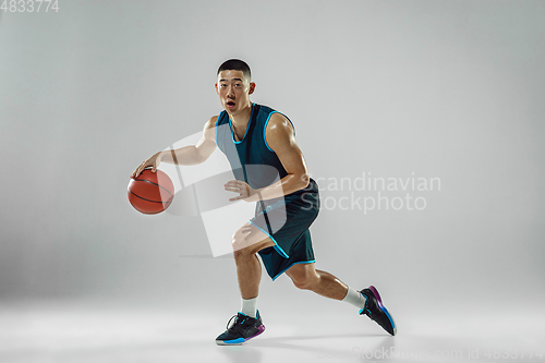 Image of Young basketball player training isolated on white studio background