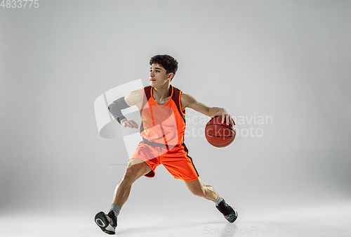 Image of Young basketball player training isolated on white studio background