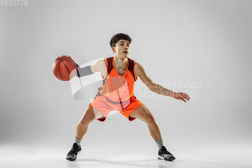 Image of Young basketball player training isolated on white studio background