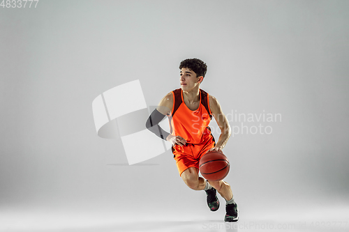 Image of Young basketball player training isolated on white studio background