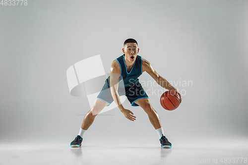 Image of Young basketball player training isolated on white studio background